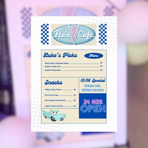 May include: A menu from Flo's Cafe, with a retro design in blue and pink. The menu lists "Luke's Picks" and "Snacks", including chicken strips and fruit cups. It also advertises a birthday special and 24-hour service, with a cartoon car graphic.