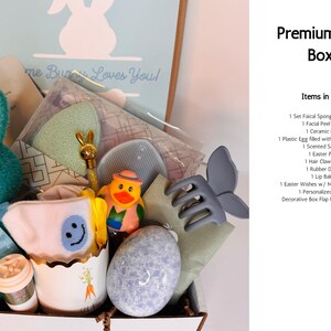 Pu&ograve; includere: Una Premium Blue Box piena di articoli a tema pasquale. Include un coniglietto verde acqua, un uovo di ceramica, una paperella di gomma, una molletta per capelli e una mini card coniglietto. La scatola &egrave; decorata con un'illustrazione di coniglietto.