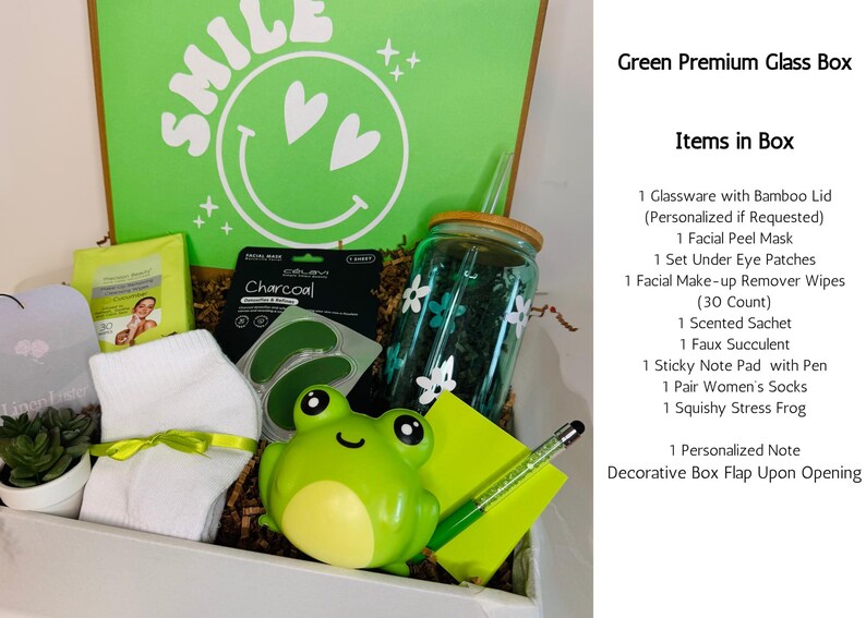 May include: A green gift box filled with self-care items. Includes a glass with a bamboo lid, facial mask, eye patches, makeup remover wipes, a scented sachet, a faux succulent, a sticky note pad with a pen, socks, and a squishy frog.
