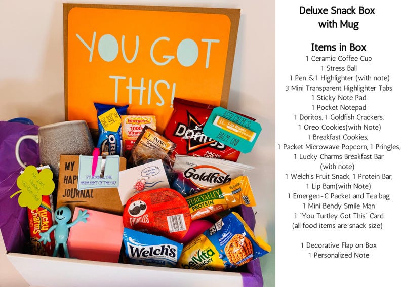 May include: A deluxe snack box with a mug, filled with various snacks, a ceramic coffee cup, and a stress ball. The box includes a notepad, highlighter tabs, and a small figurine. The box has the words "YOU GOT THIS!" on the back.