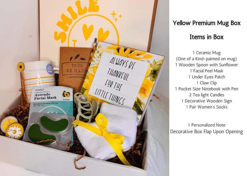 May include: A gift box filled with self-care items. Includes a ceramic mug, facial mask, socks, notebook, and a decorative sign that reads "Always be thankful for the little things." The box is decorated with yellow accents and sunflower details.