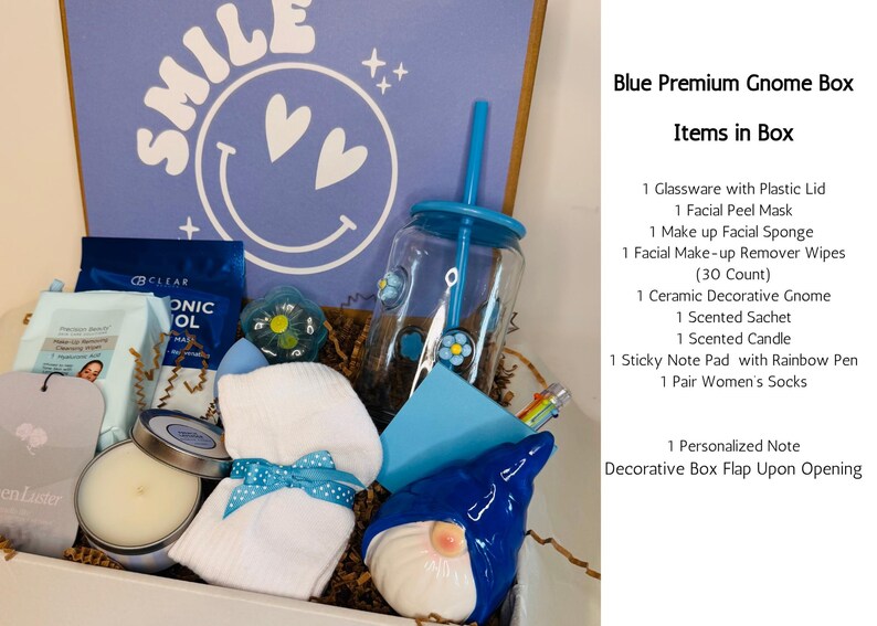May include: A blue gift box with a variety of items, including a ceramic gnome, a candle, a tumbler with a straw, and a pair of socks. The box has a blue lid with the word "SMILE" and a smiley face design.