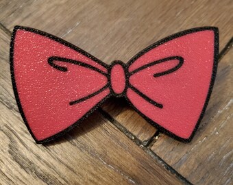 May include: A red bow tie with black outlining. The bow tie has a textured surface.