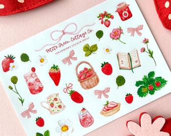 May include: A sheet of strawberry-themed stickers with illustrations of strawberries, flowers, bows, and a basket. The sheet includes the text "Petite Green Cottage Co. Strawberry Sticker Sheet". Two felt strawberry decorations are in the background.