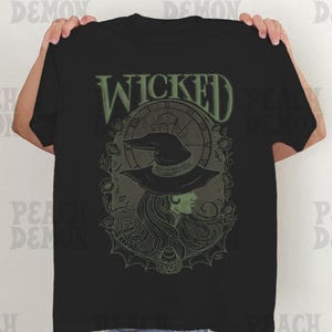May include: Black t-shirt with a green graphic of a witch with a clock and the word "WICKED" above her.