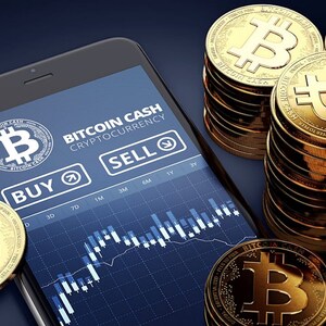 Puede incluir: Un teléfono inteligente que muestra una aplicación de comercio de criptomonedas Bitcoin Cash con botones de compra y venta y un gráfico. La pantalla muestra un fondo azul con texto blanco y un gráfico en blanco y negro. Hay varias monedas de oro Bitcoin Cash apiladas sobre una superficie azul oscuro.
