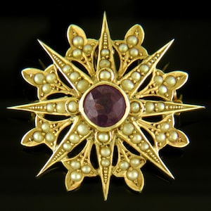 Broche antiguo de estrella y flor de lis creado por Hans Brassler en oro de 14 kt con detalles de amatista y perla alrededor de 1910