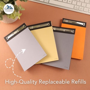 May include: Four different coloured clipboards with replaceable refills. The clipboards are grey, yellow, orange, and light blue. The clipboards have a metal clip at the top and the text "C-PLANS" is printed on the bottom right corner of each clipboard.