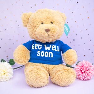 Teddy Bear Holding A Purple Sign That Says Get Well Soon Stock