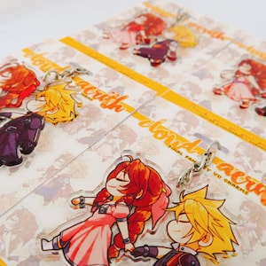 May include: Set of four colourful acrylic charms featuring characters from the Final Fantasy VII video game. The charms are on a white background with yellow text that reads "cloud & aerith final fantasy vii charms".