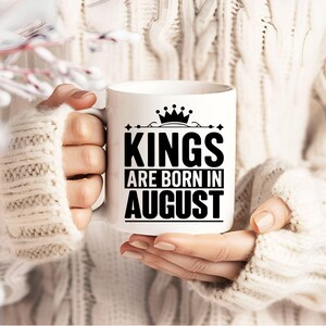 May include: White ceramic mug with a black design that says "Kings are born in August" with a crown above the word "Kings".