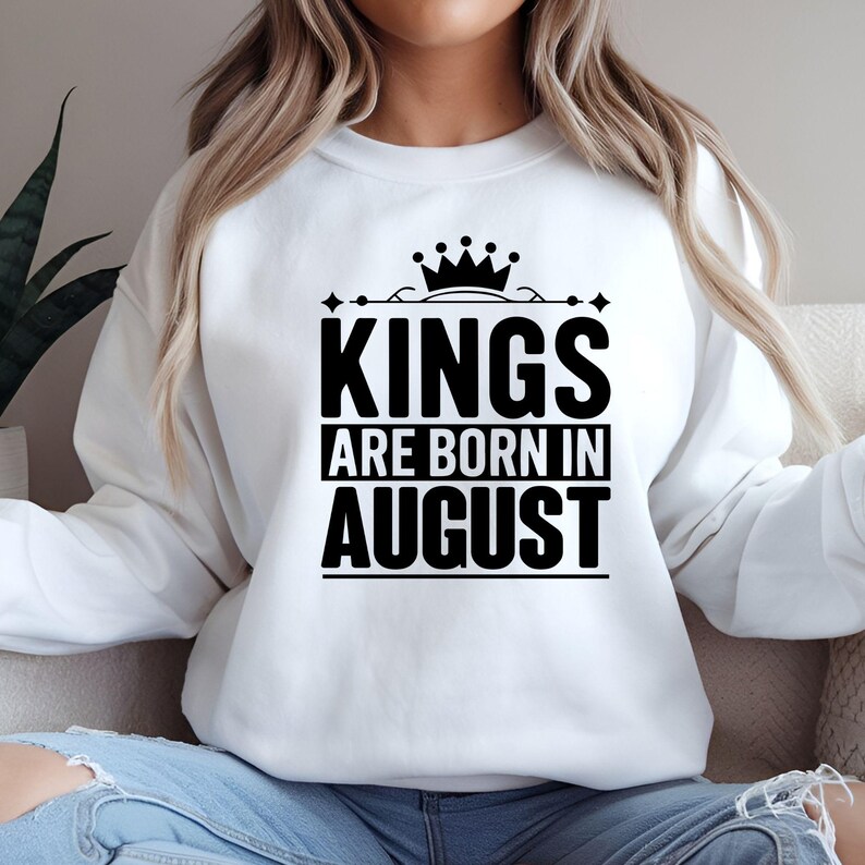 May include: White sweatshirt with black text that reads "Kings are born in August" with a crown above the word "Kings".