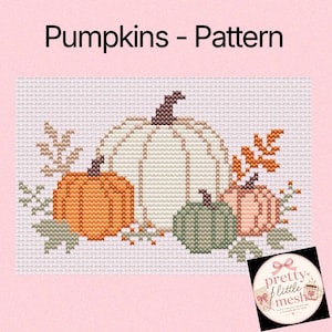 Może przedstawiać: Wzór do haftu krzyżykowego zatytułowany Pumpkins - Pattern przedstawiający dużą białą dynię pośrodku, mniejszą pomarańczową dynię po lewej stronie, zieloną dynię oraz jasnoróżową dynię, otoczone małymi pomarańczowymi i zielonymi motywami liści na białej tkaninie.