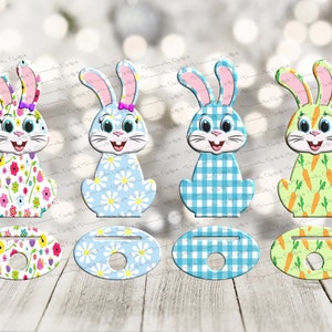 May include: Four Easter bunny themed cupcake toppers. Each topper features a different pattern: floral, daisy, plaid, and carrots. The toppers are made of wood and have a hole in the center for inserting a cupcake stick.