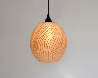 May include: A white, round pendant light with a textured, wavy pattern. The light is hanging from a black cord.