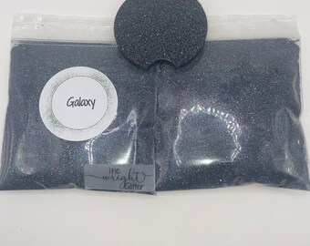 May include: A clear plastic bag filled with black glitter labeled "Galaxy" and a matching black glitter car coaster. The bag has a small label that says "ine wright glitter".