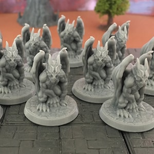 Puede incluir: Un conjunto de diez figuras de gárgolas grises, cada una con alas y una cara esculpida detallada. Las gárgolas están en posición sentada con las alas extendidas.