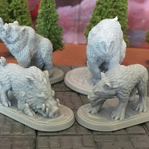 Peut inclure: Quatre figurines miniatures d'animaux, peintes en gris clair, sont présentées sur des socles individuels. Les figurines représentent un ours, un sanglier, un loup et un hibou. Les figurines sont en plastique texturé.