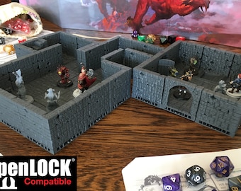May include: A set of two gray, modular dungeon tiles with a stone texture. The tiles are compatible with OpenLOCK and feature a doorway, an archway, and a small room. The tiles are set up on a wooden table with miniature figures and dice.