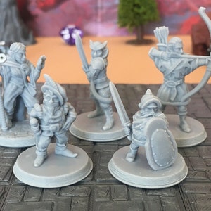 Könnte beinhalten: Fünf graue 3D-gedruckte Miniaturfiguren von Fantasy-Charakteren. Die Figuren umfassen einen Zauberer, einen Krieger, einen Zwerg, einen Waldläufer und einen Ritter. Die Figuren stehen auf runden Sockeln.