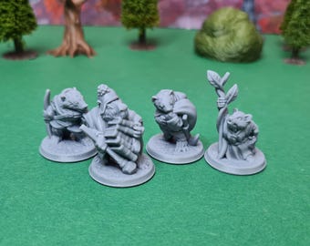 Könnte beinhalten: Vier grau bemalte Miniaturfiguren von kleinen Tieren, möglicherweise Wiesel oder Dachse, die verschiedene Kleidung tragen und verschiedene Gegenstände halten. Die Figuren stehen auf runden Sockeln.