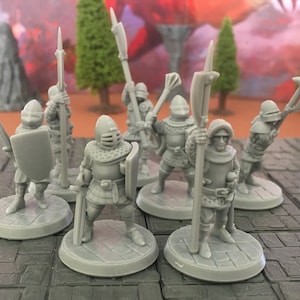 May include: A group of grey miniature medieval soldiers, each on a circular base. The figures are equipped with helmets, armour, shields, swords, and spears, suggesting a fantasy or historical theme.