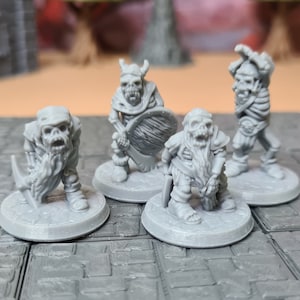 May include: Four grey painted miniature figures of undead goblins, each with a different pose and weapon. The figures are standing on a grey and white tiled surface.