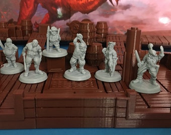 Puede incluir: Un conjunto de seis figuras de piratas de plástico gris sobre una base de madera marrón. Las figuras están todas en diferentes poses y sostienen varias armas y accesorios.