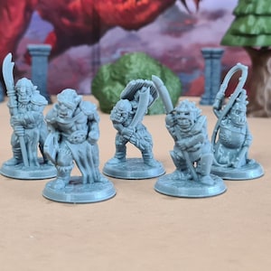 May include: Five gray miniature fantasy figures, each on a circular base. The figures are in various action poses, holding weapons such as swords, a whip, and a staff. The background includes miniature trees and rock formations.
