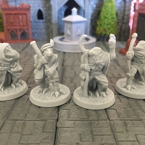 Könnte beinhalten: Vier graue bemalte Miniaturfiguren von vogelartigen Kreaturen mit verschiedenen Posen und Accessoires. Die Figuren stehen auf runden Sockeln.