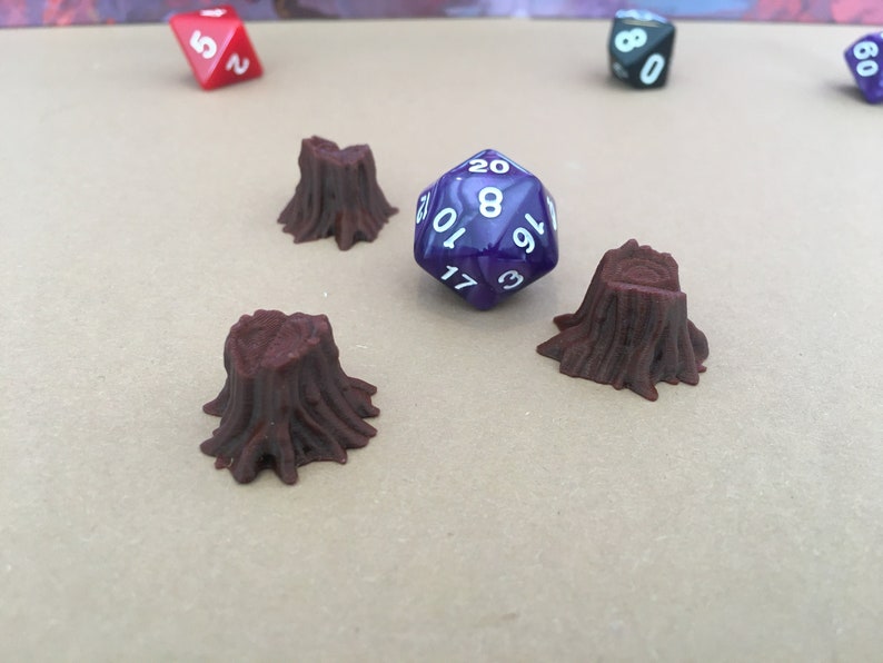 May include: Three brown tree stump miniatures and a purple 20-sided die with white numbers. The die is rolled and resting on the table.