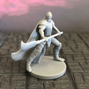 May include: A gray plastic miniature figurine of a knight wearing armor and a cape, holding a spear with a large blade. The knight is standing on a round base.