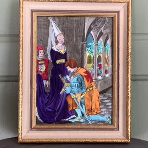 May include: A framed illustration depicting a knight kneeling before a woman in a purple gown. The knight is wearing armour and a red and orange tunic. The woman is holding a sword. The background is a medieval setting with arches and greenery.