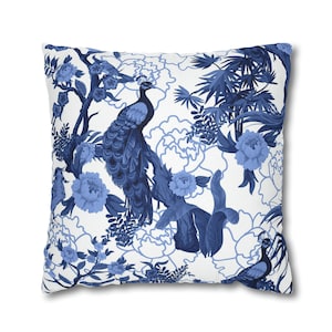 May include: Blue and white throw pillow with a floral and peacock design. The pillow features a repeating pattern of peacocks, flowers, and leaves.