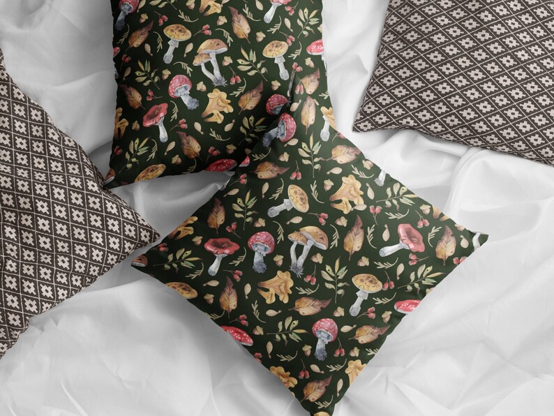 May include: Two throw pillows with a green background and a pattern of mushrooms, leaves, and berries. One pillow has a brown and white geometric pattern.