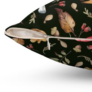 May include: A black pillowcase with a zipper closure features a repeating pattern of autumn leaves, acorns, and berries. The leaves are in shades of brown, orange, and yellow, and the berries are red.
