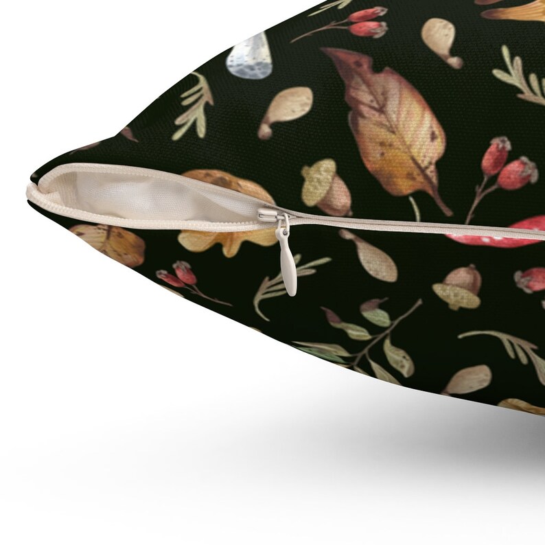 May include: A black pillowcase with a zipper closure features a repeating pattern of autumn leaves, acorns, and berries. The leaves are in shades of brown, orange, and yellow, and the berries are red.
