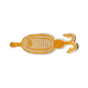 May include: A gold embroidered patch of a stylized seahorse with a tail that curls into a hook.