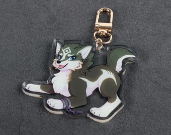 May include: A clear acrylic keychain featuring a stylized wolf with green, white, and brown fur. The wolf has blue eyes and a gold-colored clasp. The keychain is designed with a cartoonish aesthetic.