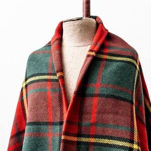 May include: A red, green and yellow plaid throw blanket draped over a mannequin.