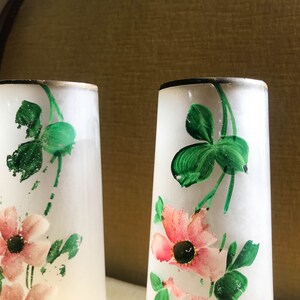 Peut inclure: Deux vases en verre givr&eacute; avec un bord dor&eacute;, d&eacute;cor&eacute;s de tr&egrave;fles verts peints &agrave; la main et de fleurs roses.
