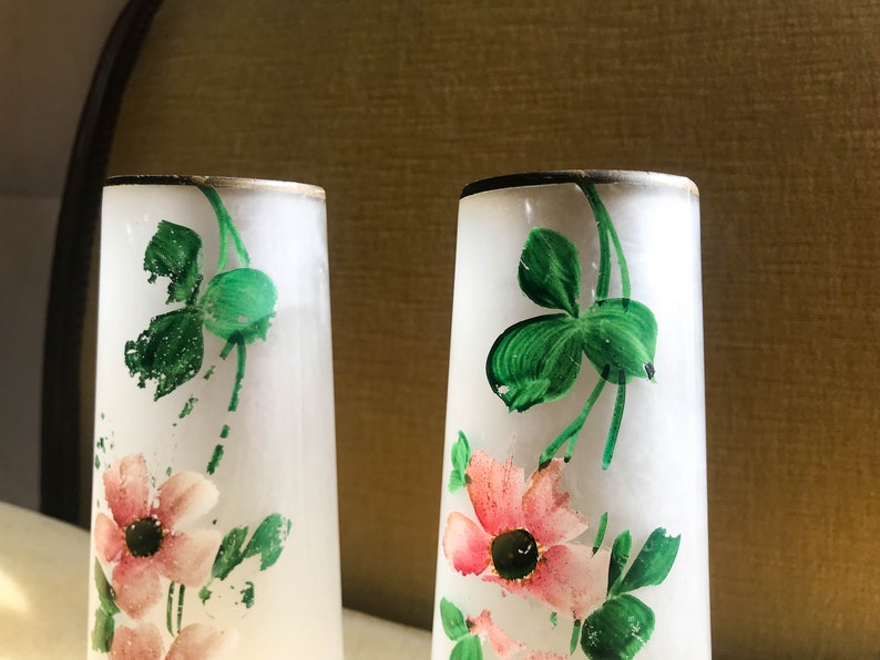 Peut inclure: Deux vases en verre givr&eacute; avec un bord dor&eacute;, d&eacute;cor&eacute;s de tr&egrave;fles verts peints &agrave; la main et de fleurs roses.