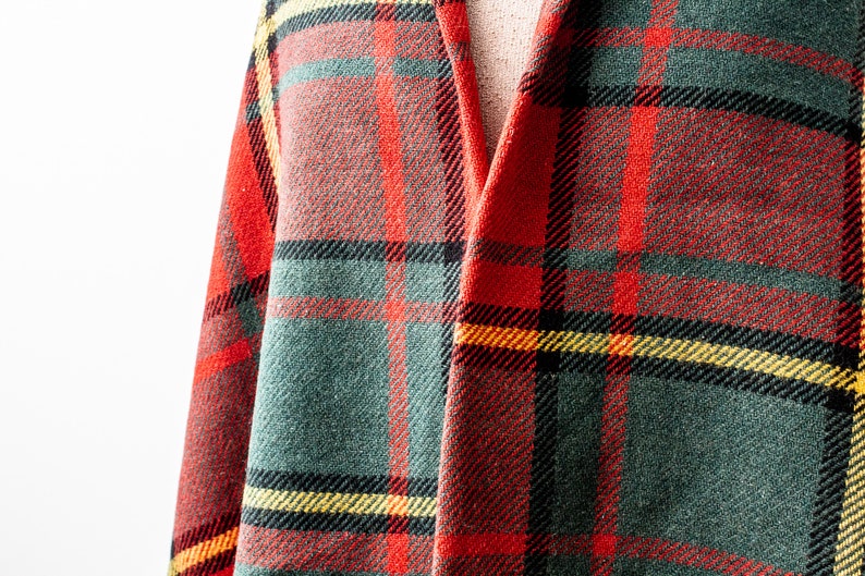May include: Red, green and yellow plaid fabric with a woven texture.