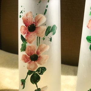 Peut inclure: Deux bouteilles en verre givr&eacute; avec des motifs floraux roses et verts. Les bouteilles sont transparentes et ont une surface textur&eacute;e.