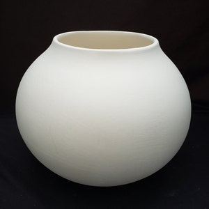 May include: A white ceramic vase with a round, bulbous shape. The vase has a smooth, matte finish.