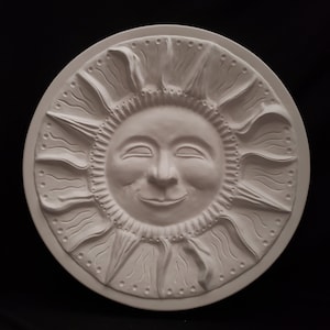 May include: A white ceramic sun wall plaque with a smiling face and raised rays. The sun has a detailed face with closed eyes and a small mouth.