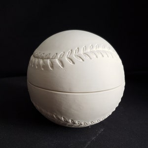 May include: A white baseball-shaped ceramic container with a lid. The container features raised stitching and decorative leaf patterns. The baseball-themed box is likely used for storage or display.