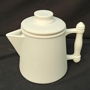 May include: Off-white ceramic coffee pot with a lid and handle. The pot has a classic design with a spout and a rounded body. The handle is curved and has a decorative element at the top. The lid is circular and sits on top of the pot.