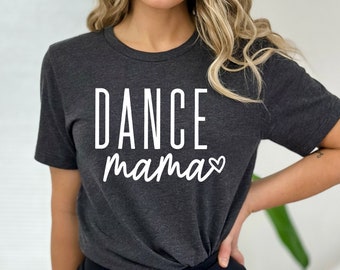 以下が含まれることがあります： 「DANCE mama」の白い文字とハートのシンボルが入った濃いグレーのTシャツ。クルーネックのスタイルで、柔らかい素材で作られているようです。テキストはシャツの前面の中央に配置されています。