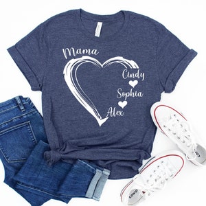 May include: A navy blue t-shirt with a white heart design and the text "Mama" at the top. Inside the heart are the names "Cindy", "Sophia", and "Alex" with small hearts next to each name.